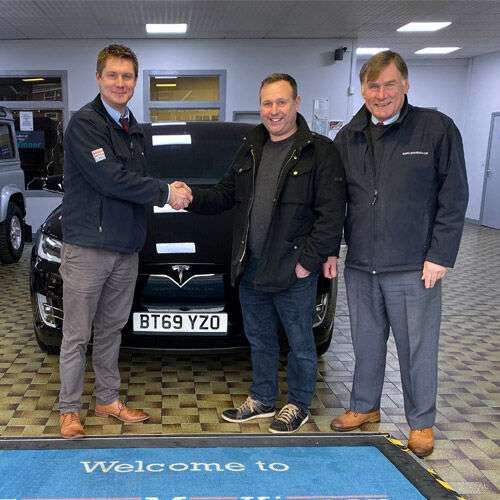 Stuart MacKinnon (left) and Angus MacKinnon (right) with a customer (centre). Stuart is shaking the customer's hand.